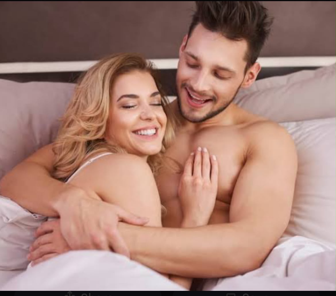 A happy couple smiling together in bed